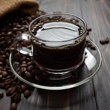 Hot coffee in a glass on the wooden table.